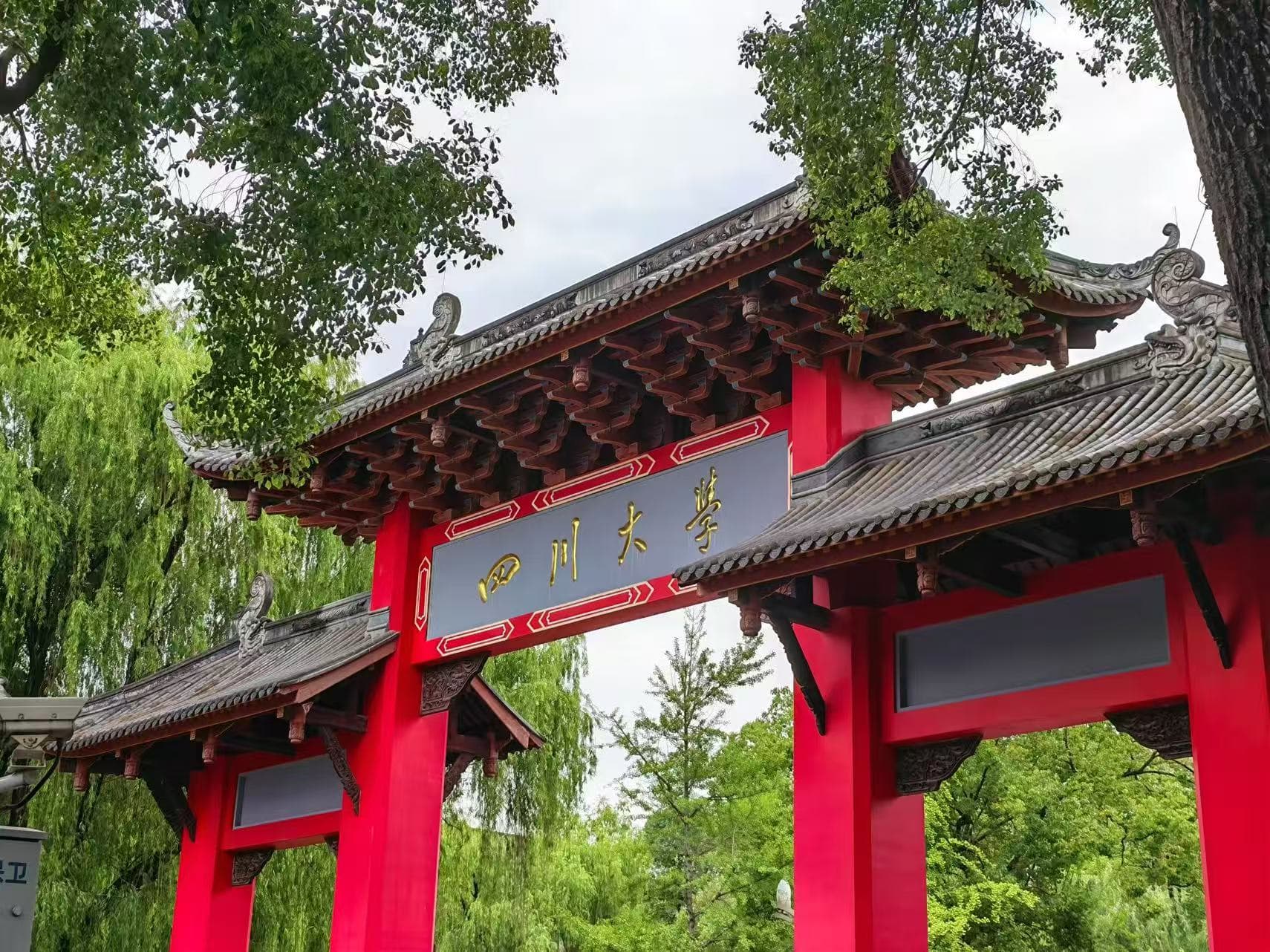绿树环绕的四川大学红色校门