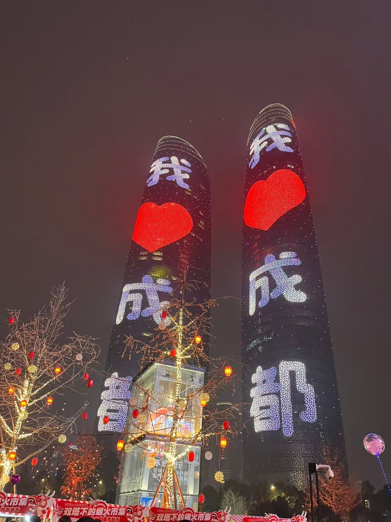 夜间双塔亮起我爱成都的灯光