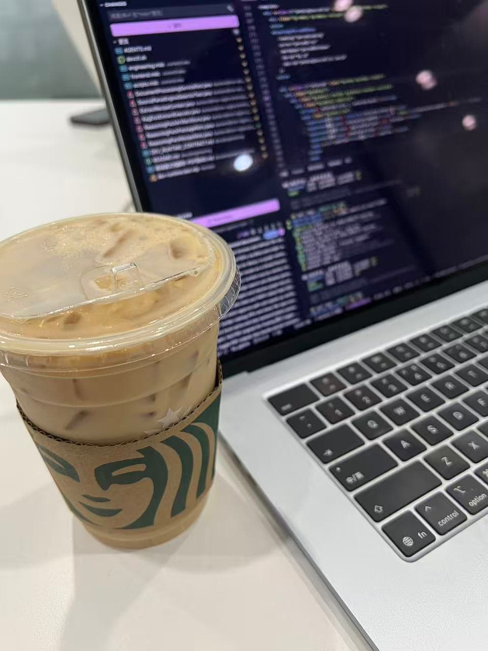 A Starbucks iced coffee on the left and a laptop on the right