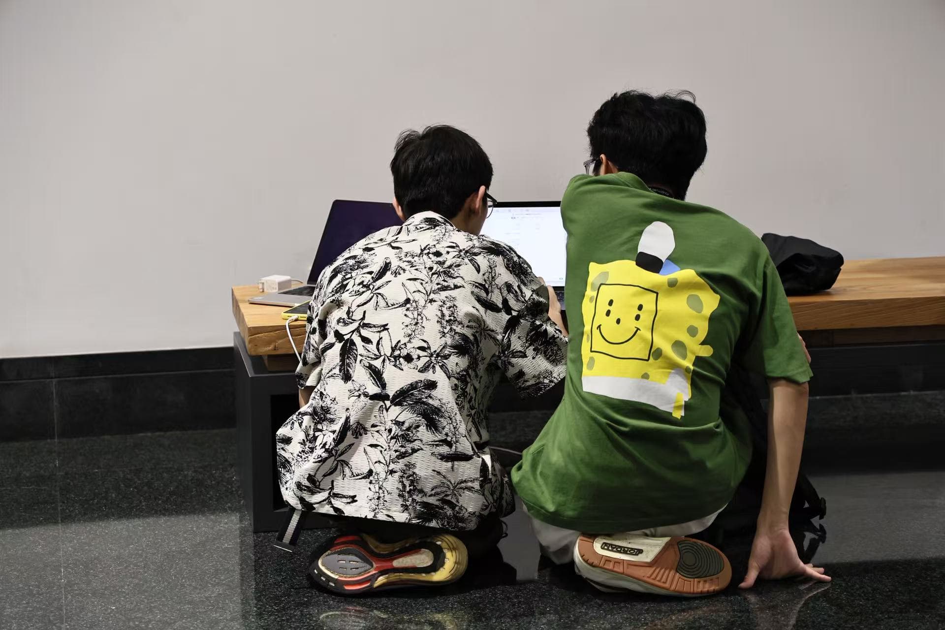 Two people working together at a laptop